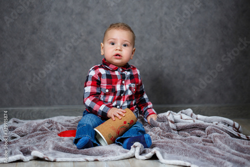 little boy ten months old in a shirt and jeans