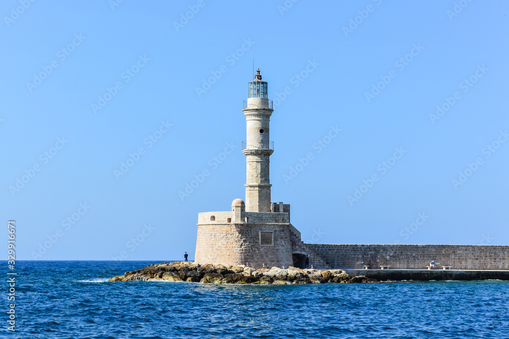 A beautiful lighthouse, as one of the most famous attraction, at the entrance of the old Venetian harbour at city of Chania, Crete, Greece.