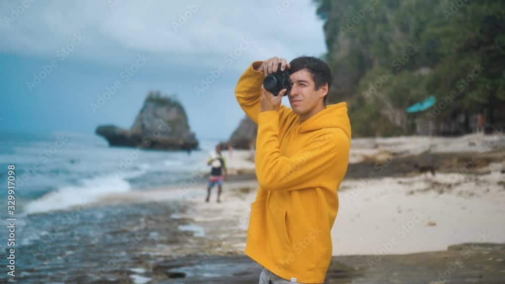 Nature photographer photographing ocean waves on sunset at beautiful tropical beach. Male traveler photographer makes professional pictures for blog. Nature photographer photographing ocean waves on sunset at beautiful tropical beach. Male traveler photographer makes professional pictures for blog.