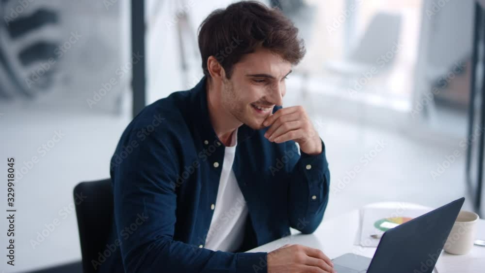 Businessman looking financial charts on notebook. Cheerful guy analyzing charts