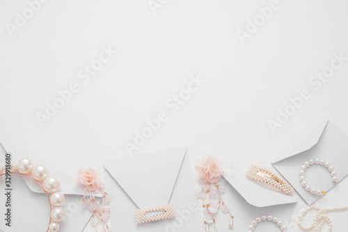 The wedding background with space for text, decorated with invitation envelopes and decorations for the bride, is made in soft pastel colors, with copy space. Conceptual backgrounds for wedding texts.