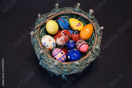 green Easter basket with colorful Easter eggs photo