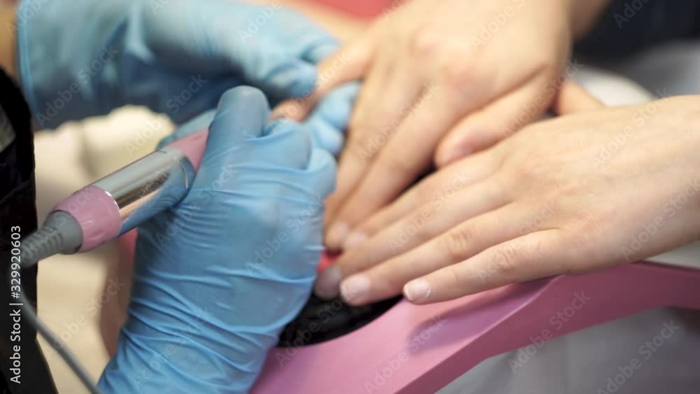 Manicurist polishes the nails of the client. Close-Up Manicurist polishes the nails of the client. Close-Up