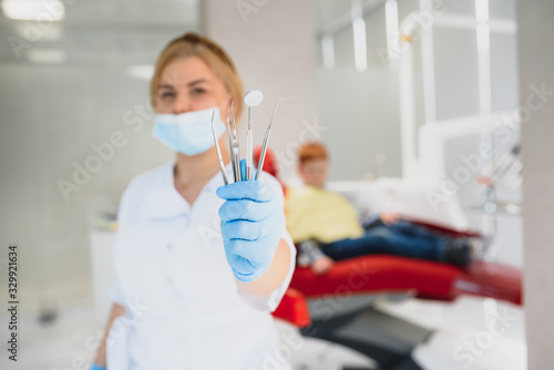 Portrait of a dentist holding dental instruments in his hands in the clinic close-up