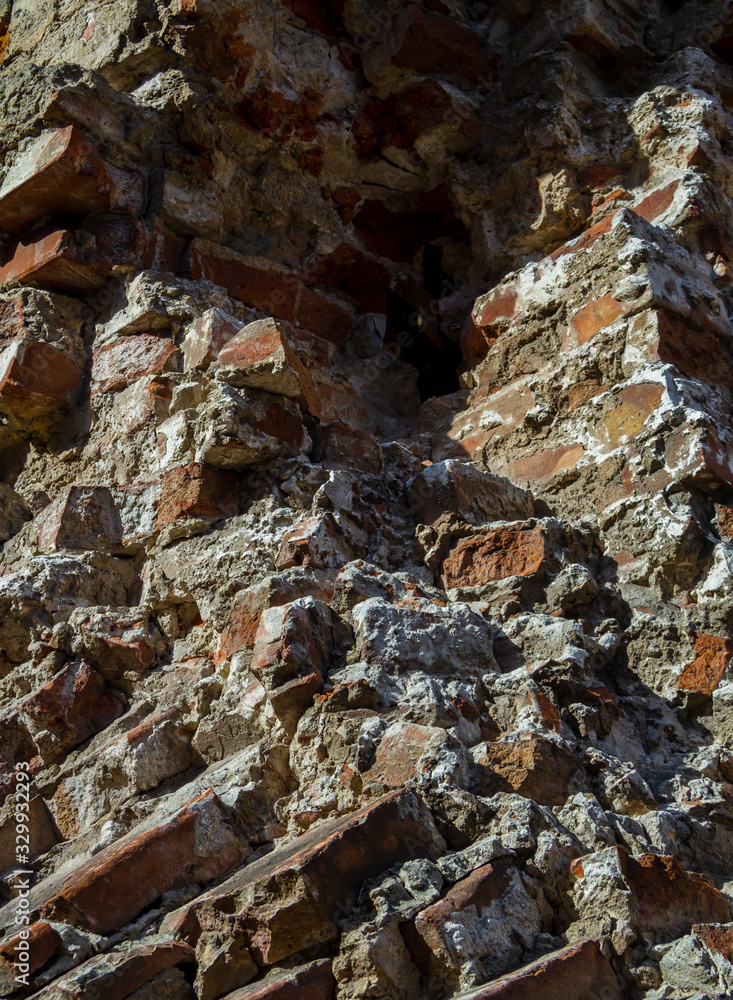 Fototapeta premium The ruins of an old brick abandoned house look like after the bombing