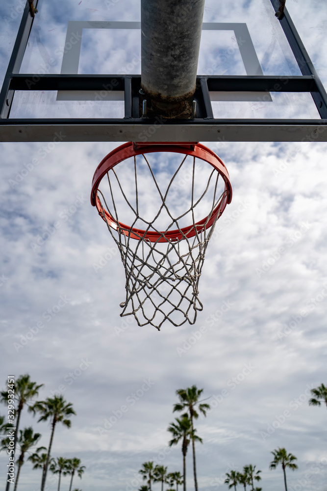 Outdoor basketball rim on a cloudy and sunny day