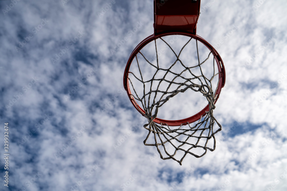 Outdoor basketball rim on a cloudy and sunny day