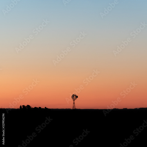 Silhouette of a windmill at sunset