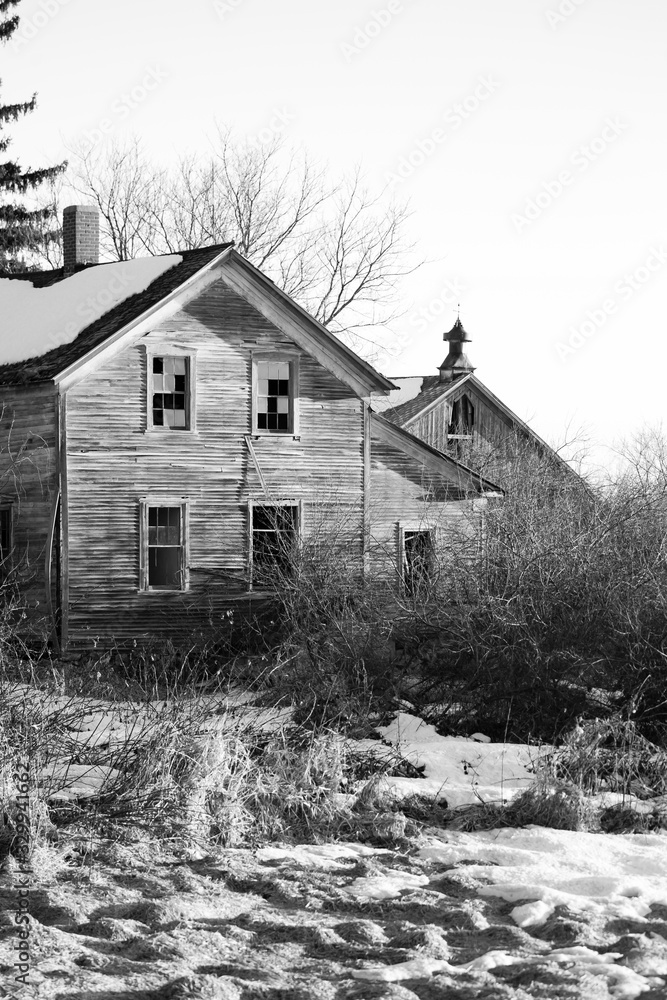 Black and white image of an old abandoned house and barn in Wisconsin, vertical Black and white image of an old abandoned house and barn in Wisconsin, vertical