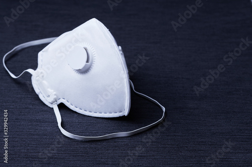 White ffp3 face mask with a valve on a dark background