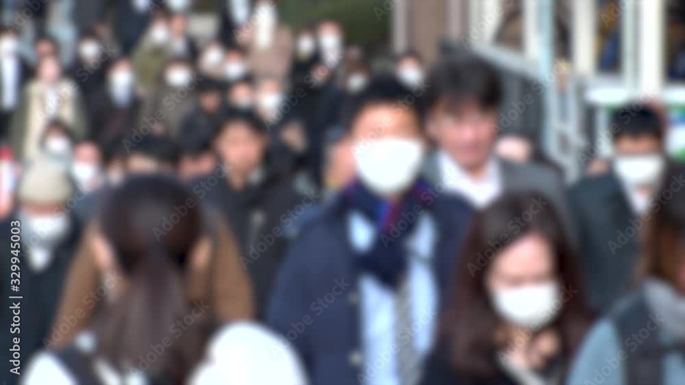 TOKYO, JAPAN -MARCH 2020 : Crowd of people walking down the street in morning rush hour. Commuters going to work. People wearing mask to protect from Coronavirus(COVID-19) or cold. Blurred slow motion TOKYO, JAPAN -MARCH 2020 : Crowd of people walking down the street in morning rush hour. Commuters going to work. People wearing mask to protect from Coronavirus(COVID-19) or cold. Blurred slow motion