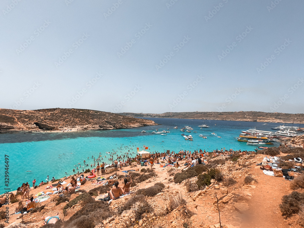 Residents and tourists enjoy at Comino Beach, Malta. One of the most visited beaches in Malta, where most people enjoy the weather, beaches and attractions.