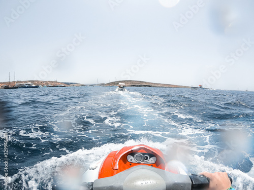 Close-up of a person riding a jet ski on the island of Cumin, while enjoying the summer. photo