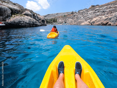 Tourists practicing kayaking on one of the beaches on the island of Gozo, Malta. People enjoying summer on the beach.