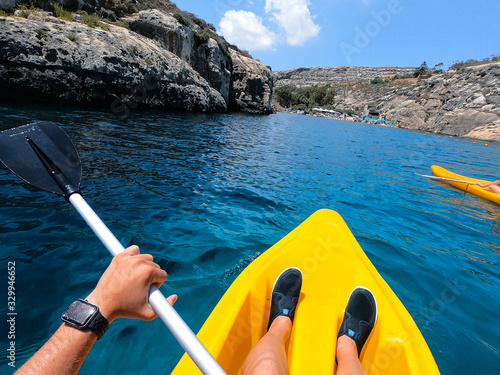Tourists practicing kayaking on one of the beaches on the island of Gozo, Malta. People enjoying summer on the beach.