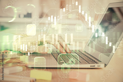 Double exposure of stock market graph with man working on laptop on background. Concept of financial analysis.