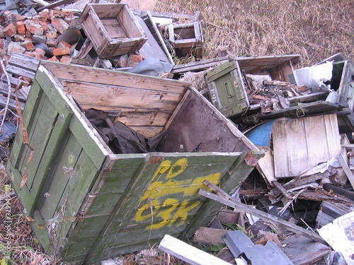 discarded broken wooden storage boxes in a landfill in the trash military supplies