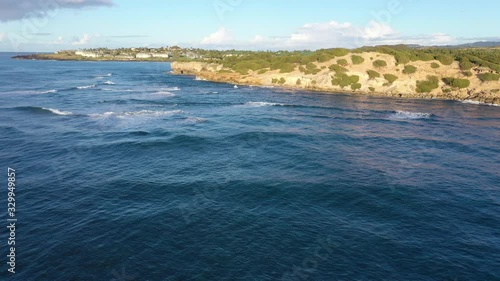 Low elevation arial video chasing, following, waves as they approach the rocky coast and finally break, Shipwreck Beach #1, Poipu, Koloa, Kauai, Hawaii photo