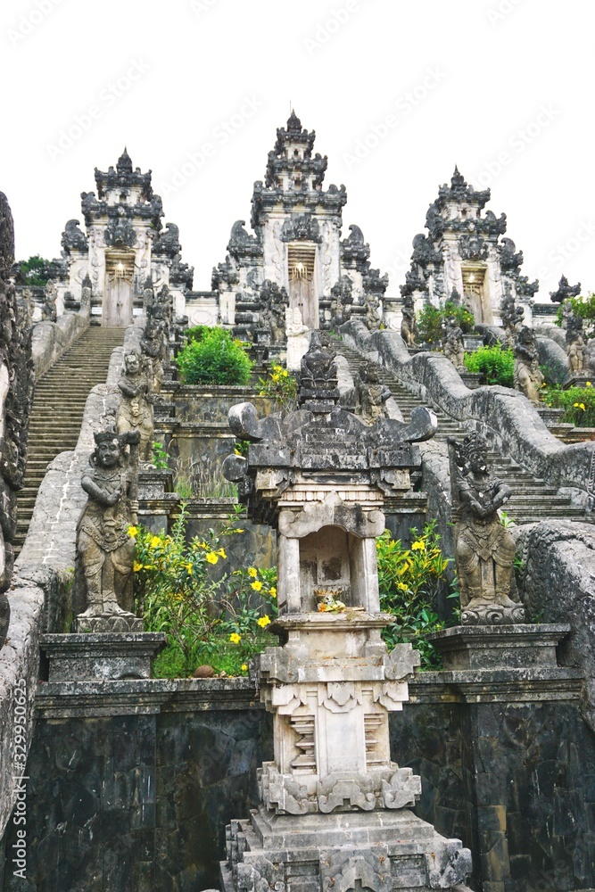 Ancient Indonesian temple pagodas with ornate stone stairs leading up the hill in Bali Indonesia