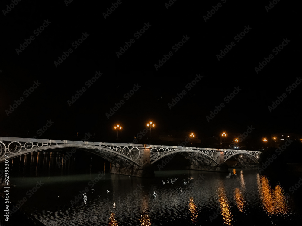 Triana Bridge from the Guadalquivir River at night.