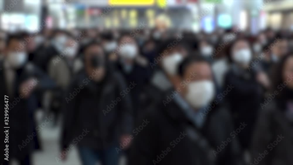 TOKYO, JAPAN - MARCH 2020 : Crowd of people walking at Shinagawa station in morning rush hour. Commuters going to work. People wearing mask to protect from Coronavirus(COVID-19). Blurred slow motion. TOKYO, JAPAN - MARCH 2020 : Crowd of people walking at Shinagawa station in morning rush hour. Commuters going to work. People wearing mask to protect from Coronavirus(COVID-19). Blurred slow motion.