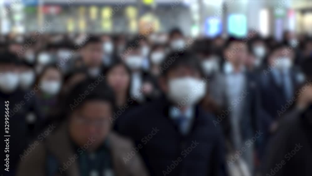 TOKYO, JAPAN - MARCH 2020 : Crowd of people walking at Shinagawa station in morning rush hour. Commuters going to work. People wearing mask to protect from Coronavirus(COVID-19). Blurred slow motion. TOKYO, JAPAN - MARCH 2020 : Crowd of people walking at Shinagawa station in morning rush hour. Commuters going to work. People wearing mask to protect from Coronavirus(COVID-19). Blurred slow motion.