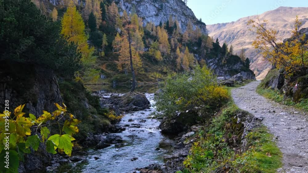Autumn alpine stream view from mountain hiking path to Tappenkarsee, Kleinarl, Land Salzburg, Austria. Picturesque hiking, seasonal, and nature beauty concept scene. Autumn alpine stream view from mountain hiking path to Tappenkarsee, Kleinarl, Land Salzburg, Austria. Picturesque hiking, seasonal, and nature beauty concept scene.