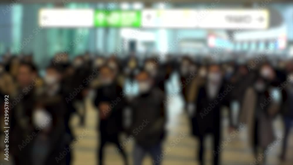 TOKYO, JAPAN - MARCH 2020 : Crowd of people walking at Shinagawa station in morning rush hour. Commuters going to work. People wearing mask to protect from Coronavirus(COVID-19). Blurred slow motion. TOKYO, JAPAN - MARCH 2020 : Crowd of people walking at Shinagawa station in morning rush hour. Commuters going to work. People wearing mask to protect from Coronavirus(COVID-19). Blurred slow motion.