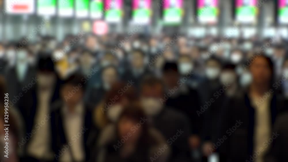 TOKYO, JAPAN - MARCH 2020 : Crowd of people walking at Shinagawa station in morning rush hour. Commuters going to work. People wearing mask to protect from Coronavirus(COVID-19). Blurred slow motion.