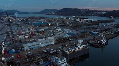 Aerial drone footage of a industrial shipyard and cargo ship loading port in Vancouver, BC, Canada. 4K 24FPS.