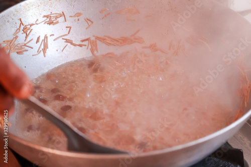 cocking savaiya noodle in kitchen,seva cocking at home and steam, almond and Cashew nuts sevaiya, photo