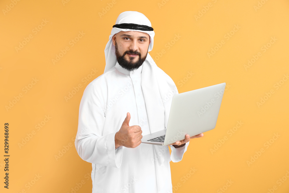 Arab businessman with laptop on color background Arab businessman with laptop on color background