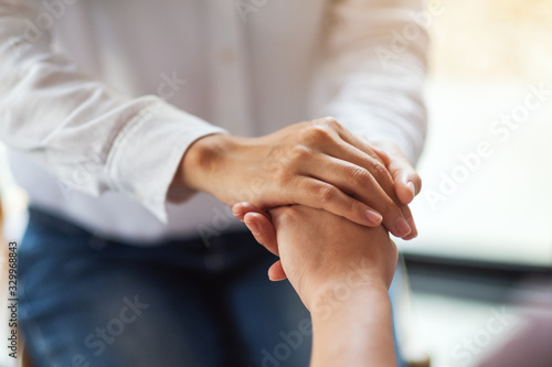 Women holding each other hands for comfort and sympathy