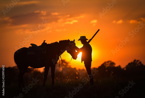 Cowboy silhouette And horses in the evening, sunset © Surachai