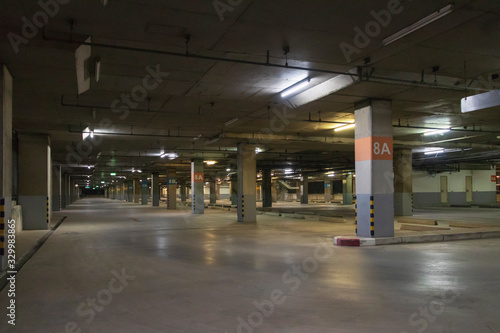 Empty parking interior at night. Parking garage at eight floor.