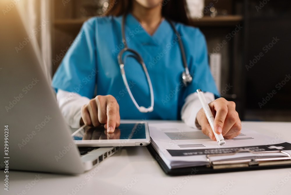 Medical technology concept. Doctor working with mobile phone and stethoscope and digital tablet laptop in modern office at hospital in morning light Medical technology concept. Doctor working with mobile phone and stethoscope and digital tablet laptop in modern office at hospital in morning light