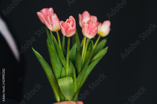 bouquet of pink tulips in men's hands