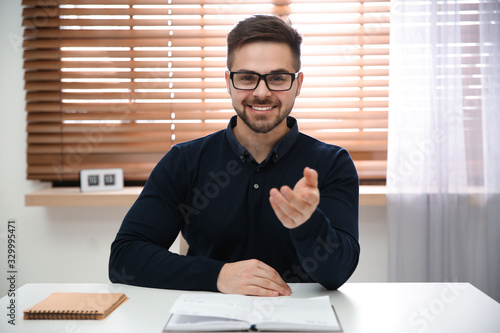 Happy man using video chat in modern office, view from web camera