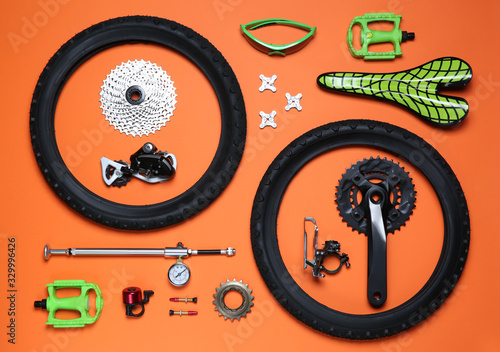 Set of different bicycle tools and parts on orange background  flat lay