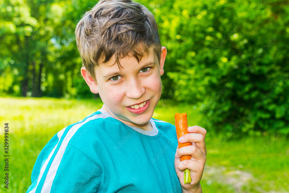teen boy with a carrot in a forest teen boy with a carrot in a forest