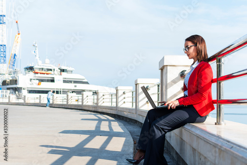Business woman working with a laptop outdoors. A woman with a laptop.