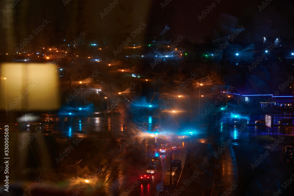 Photo of a night city from a window with beautiful colored lights