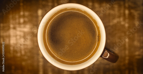 top view of a coffee cup, centered with empty space on sides. warm colours