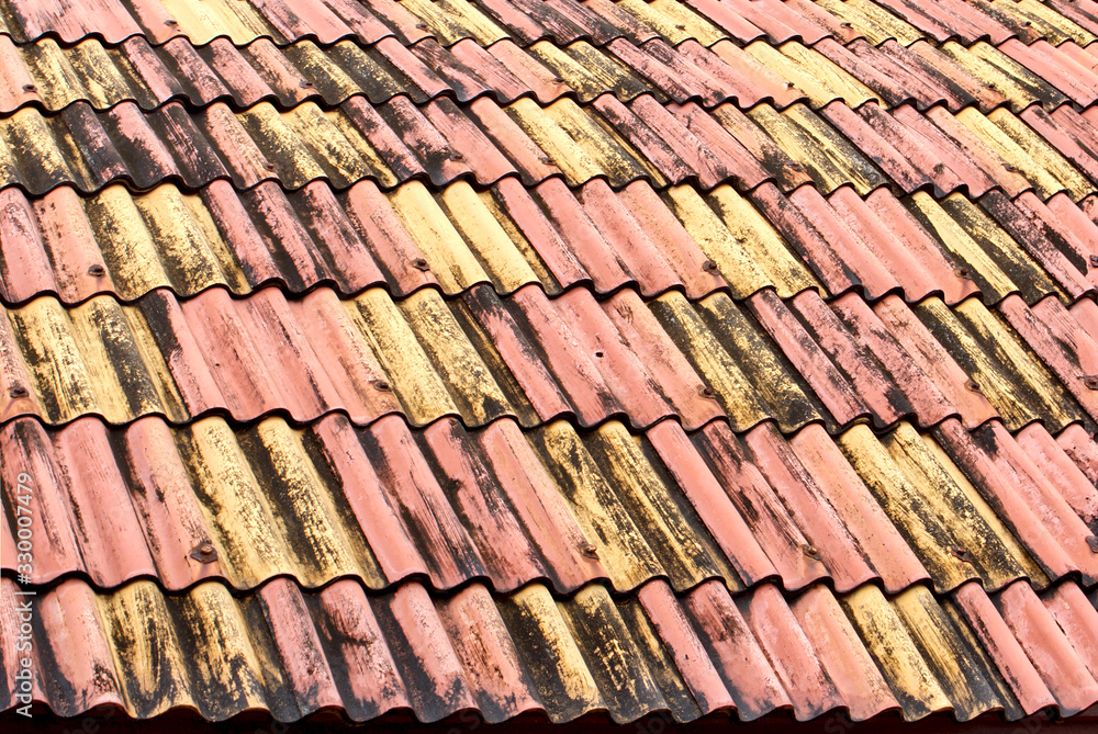 Old weathered roof tiles. close up of roof waved textures in red and yellow colors. colored tiles form a pattern. Architecture background. Thailand house. Old weathered roof tiles. close up of roof waved textures in red and yellow colors. colored tiles form a pattern. Architecture background. Thailand house.