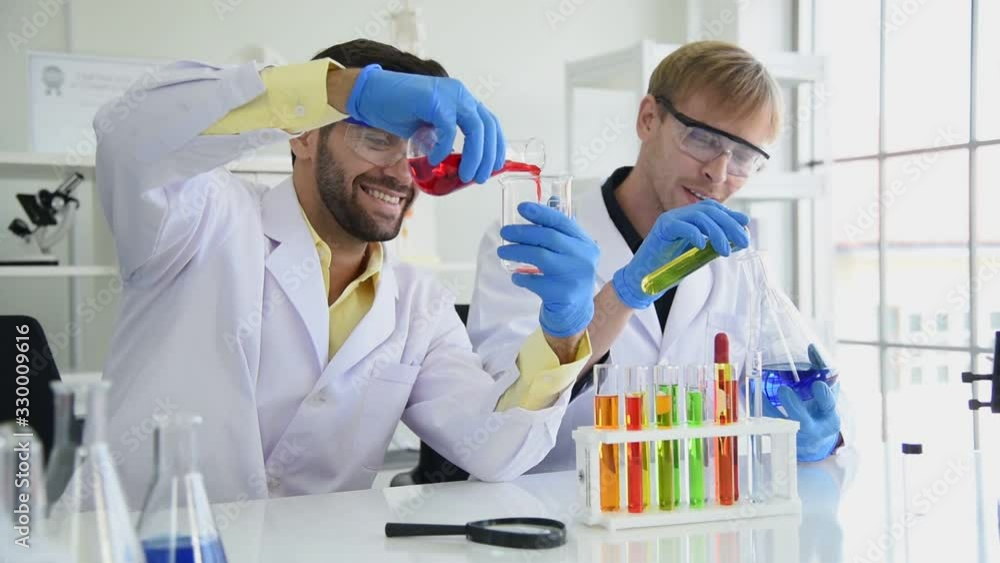 Happy scientist team working and research sample test with protection equipment and glasses in laboratory room Happy scientist team working and research sample test with protection equipment and glasses in laboratory room
