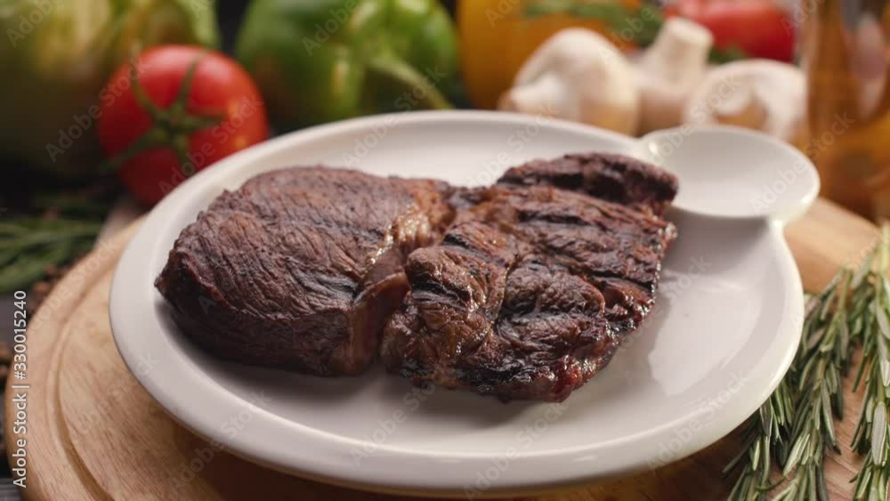 Steak on a wooden board with a sprig of rosemary. Steak on a wooden board with a sprig of rosemary.