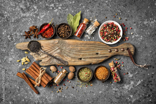 Fototapeta Naklejka Na Ścianę i Meble -  Different spices, kitchen herbs and seeds for tasty meals with wooden board