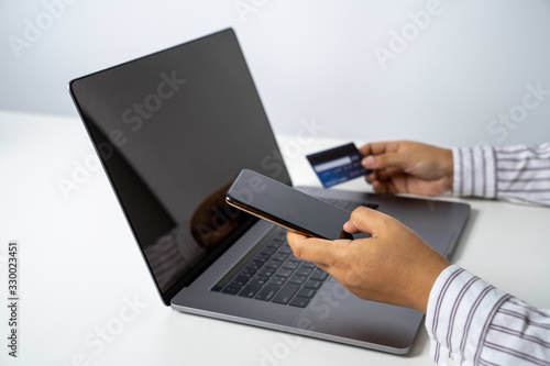 Person using online banking with credit card on touch screen device. Internet online banking. Digital and internet payments shopping on network. All on screen and credit card are designed up.