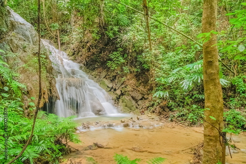 view of silky waterfall flowing around with green forest background, Pu Kaeng Waterfall, Doi Luang National Park, Chiang Rai, Northern of Thailand. photo