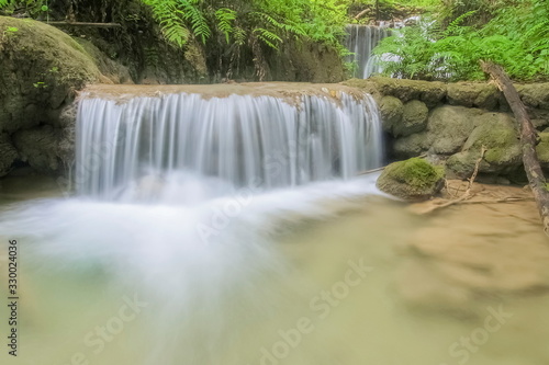 view of silky waterfall flowing on the rock around with green forest background  Pu Kaeng Waterfall  Doi Luang National Park  Chiang Rai  Northern of Thailand.